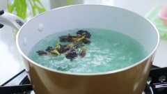 Cho khoảng 15 hoa đậu biếc vào nồi nước đã sôi, các bạn đun khoảng 5 - 7 phút, nước chuyển qua màu xanh đậm là được. Đợi nước nguội rồi cho nước vào khay làm đá. Dùng rây để lược lại phần xác. Để đông trong tủ lạnh.