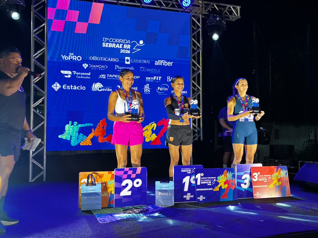 Atletas recebendo premiação no pódio durante a 13ª edição da Corrida Sebrae em Roraima