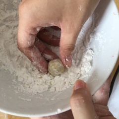 Lấy từng viên bột nhỏ cho vào tay rồi vo tròn lại kích thước tròn bằng hạt lạc là được. Tiếp theo, áo viên tròn qua một lớp bột năng rồi dùng rây lược qua để loại bớt phần bột dư thừa.