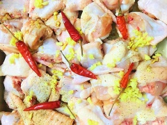 Chọn phần cánh gà để có nhiều thịt mà ít xương, béo dai và thơm hơn. Chặt cánh gà thành từng miếng nhỏ vừa ăn. Ướp gà với gừng, tỏi băm, ớt trái và tiêu.