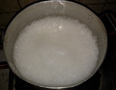 Cho gạo tẻ vào nồi cùng 1 lít nước, nấu sôi. Luộc sơ qua lườn gà, vớt ra, xé thành sợi.