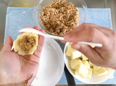 Giờ là bước tác thành cho nhân và vỏ. Cắt khối bột khoai thành các phần nhỏ bằng nhau. Ấn dẹt rồi bao nhân lại như cách làm bánh trôi tàu. Chuẩn bị 1 đĩa sâu lòng, rắc bột năng lên để lăn bột khoai lên. (làm như vậy để sau khi luộc bánh khoai, khoai không bị nứt, mà lại có một lớp bóng bẩy bên ngoài mặt, trông rất đẹp)