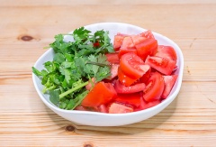 Thịt cá làm sạch, cắt thành miếng vừa ăn. Hành lá cắt gốc, bóc vỏ, rửa sạch rồi cắt khúc ngắn cỡ 4cm. Cho thịt cá vào tô, ướp cá với gừng , hành lá, 1 muỗng cà phê muối, trộn đều lên, để cá 15 phút cho thấm gia vị. Cà chua rửa sạch, cắt múi cau. Ngò cắt gốc, xắt nhỏ.