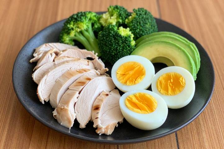 Здоровая тарелка с вареными яйцами, куриной грудкой и свежими овощами