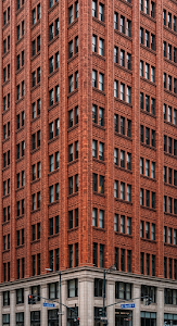 Close-Up of an Ornate Orange Terracotta Skyscraper Corner with Repeating Window Pattern