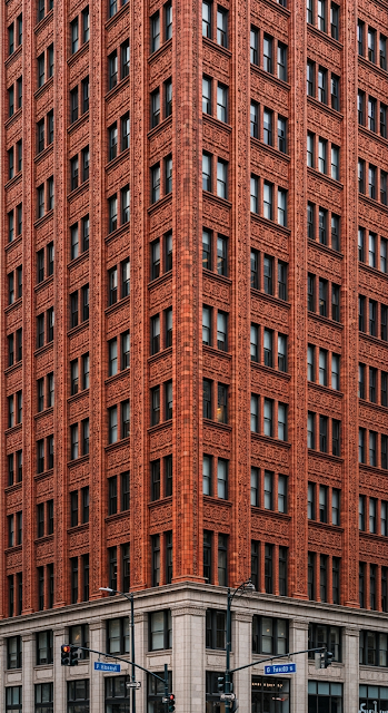 Close-Up of an Ornate Orange Terracotta Skyscraper Corner with Repeating Window Pattern - Free mobile Wallpaper