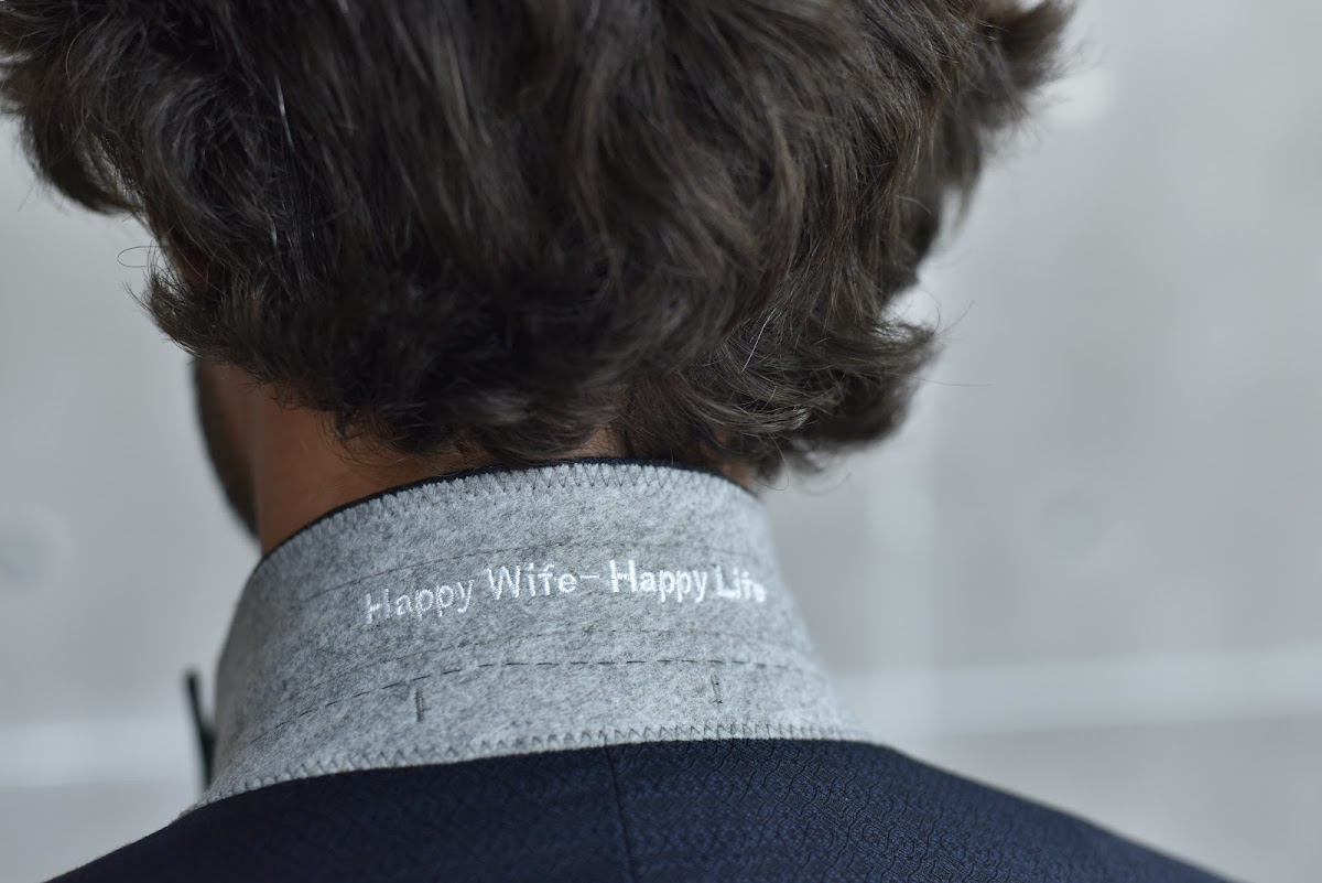 master tailor hand-finishing custom jacket lapel