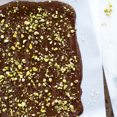 Hạt dẻ cười giã giập. Chocolate bạn cho vào nồi hấp cách thủy cho đến khi tan chảy. Chuẩn bị 1 cái khay rộng có lót sẵn giấy sáp hoặc giấy nến. Dùng dao phết trải đều chocolate ra, nhân lúc chocolate còn ấm, bạn nhanh tay rải hạt dẻ cười lên mặt chocolate.