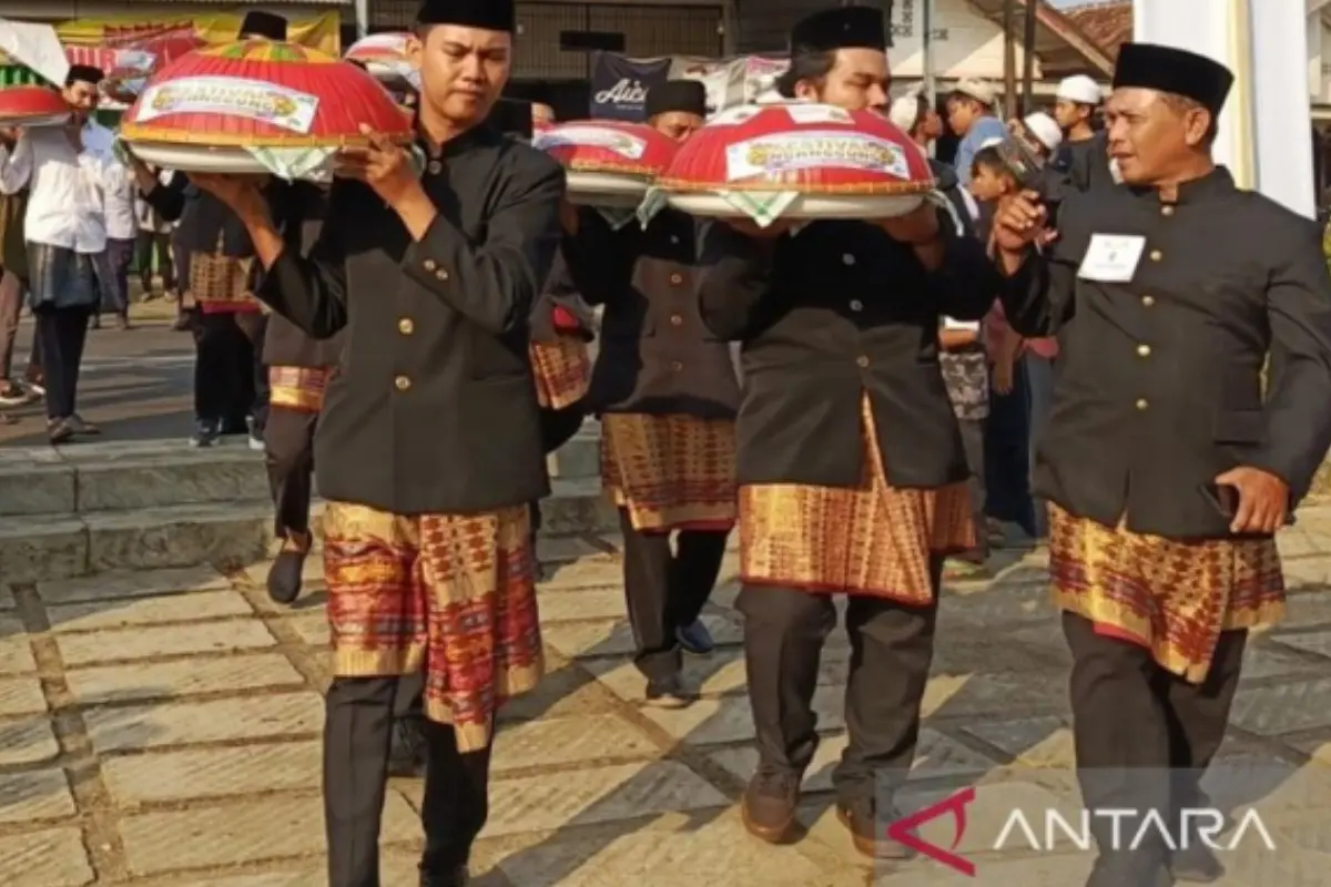 Masyarakat Bangka sedang melaksanakan tradisi Nganggung dengan membawa dulang berisi makanan.