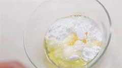 2 quả trứng gà còn lại, đập ra tô, tách lấy lòng trắng. Cho đường bột, 10ml nước cốt chanh vào, khuấy đều.