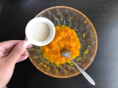 Bí đỏ thái lát mỏng, đem hấp chín. Sau đó cho bí vào tô dùng nĩa nghiền mịn. Cho vào tô bí đỏ gồm: 200g bột nếp, 3g men nở và 30g đường, trộn đều rồi dùng tay nhồi thành khối đồng nhất.