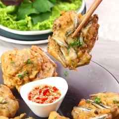 Trình bày món ăn ra dĩa, tranh trí thêm ít ngò rí rắc lên trên bánh để trông đẹp mắt hơn. Cá cơm chiên bột được dùng kèm với xà lách và rau thơm, chấm với nước chấm chua ngọt. Món ăn sẽ ngon hơn khi bạn dùng nóng sẽ giữ được độ giòn tan của bánh.