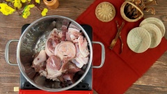 Đun nóng 2 muỗng canh dầu ăn, phi thơm 15gr hành tím và cho chân giò đã ướp vào xào săn, thêm 500ml nước dừa tươi vào nấu đến khi sôi thì cho tiếp măng khô xé sợi vào. Nêm gia vị gồm hạt nêm 1 muỗng canh, muối 1 muỗng canh, nước mắm 1 muỗng canh và 200ml nước. Hầm lửa nhỏ trong khoảng 60 phút đến khi nước cạn và chân giò, măng đã chín mềm.