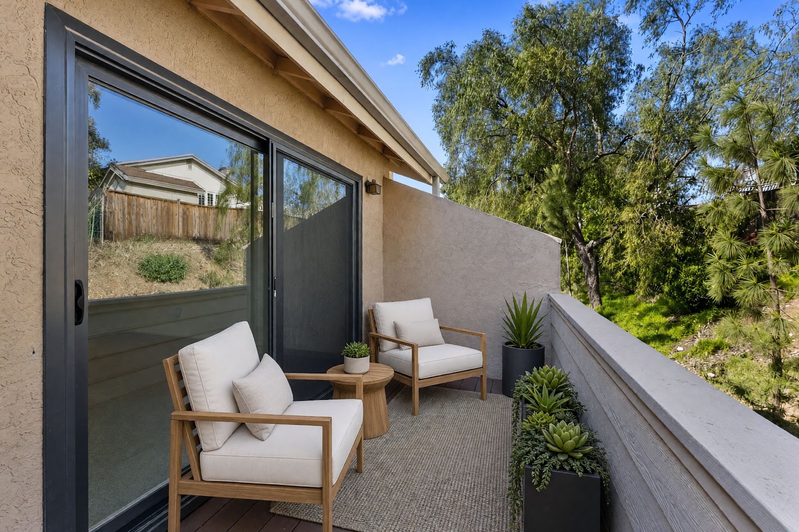 Private balcony off the primary bedroom overlooking the trees