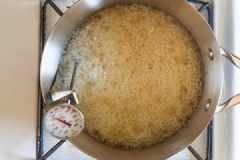 Xịt hoặc quét một lớp dầu mỏng lên khay phẳng và để riêng. Cho nước, bơ lạt, đường, tinh chất vani vào nồi, đun nóng và khuấy đều cho đường cùng bơ tan hoàn toàn. Khi đường tan, bạn vặn nhỏ lửa, đun mà không khuấy trong khoảng 8-12 phút cho đạt tới nhiệt độ 340 độ F.
