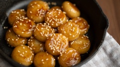 Bày trí bánh nếp chiên ngào đường ra đĩa cho đẹp mắt, có thể rắc thêm ít mè trắng rang chín thơm ngon lên trên là có thể dùng nhé! Những viên bánh nếp chiên có lớp vỏ hơi giòn bên ngoài, dẻo dai bên trong, áo đều một lớp đường nâu ngọt dịu rất hấp dẫn.