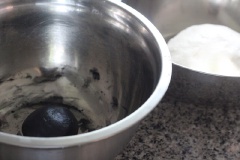 Để làm bánh bao hấp nhanh thì trước tiên cần rây bột mì cho mịn. Cho bột mì, men khô, đường, muối, dầu dừa, sữa tươi vào thố trộn đều, nhồi đến khi bột trở nên mịn màng và không dính tay là được. Phủ 1 lớp khăn ẩm lên trên thố, để cho bột nghỉ trong 60 phút. Lấy bột bánh bao ra nhồi lại một lúc cho hỗn hợp mịn, dẻo, lấy một phần bột khoảng 70gr trộn cùng với bột than tre, chia phần còn lại làm 8 phần đều nhau, vê tròn.