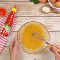 Trứng gà luộc chín 6 quả, bóc sạch vỏ. Đập 1 quả trứng còn lại vào tô, 1/2 muỗng cà phê muối và 1/2 muỗng cà phê tiêu tiêu, đánh tan đều. Cho 200gr thịt heo băm và 200gr thịt bò băm vào tô, thêm 10gr nước tương, 10gr tương ớt Vedan, 30gr bột chiên xù, 30gr hành tây băm, dùng tay nhồi đều.
