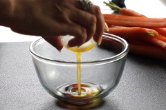 Mở lò nướng ở 190 độ C trước 10 phút. Trong âu trộn đều 1 muỗng dầu olive, 2 muỗng bơ và 2 muỗng giấm Balsamic. Cà rốt cắt bỏ phần lá xanh, giữ nguyên vỏ, rửa thật sạch, cắt làm đôi. Cho cà rốt vào khay nướng, xếp cho đều. Tỏi lột vỏ, bào mỏng.