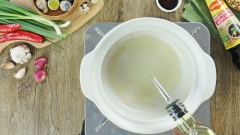 Đun nóng 2 muỗng canh dầu ăn trong nồi, cho sườn vào chiên sơ. Tiếp theo cho vào nồi 300ml nước dừa tươi rồi đun sôi. Chú ý hớt bọt thường xuyên để nước kho được trong hơn.