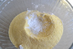 Bật trước lò nướng ở nhiệt độ 375 độ F. Quét một lớp dầu vào khuôn muffin. Chp bột mì, bột bắp vàng (loại hạt vàng, xay thô chứ không phải bột bắp trắng mịn nha), bột nở, baking soda và muối vào tô, trộn đều.