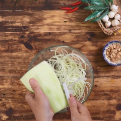 Đu đủ xanh gọt vỏ, bào sợi vừa ăn. Cho đu đủ vừa bào ngâm trong nước muối pha loãng cho sạch mủ. Sau đó cho đu đủ vào thau nước đá lạnh ngâm 10 phút cho đu đủ được giòn.