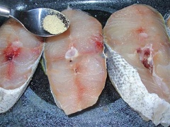 Làm nóng lò nướng đến 190 độ C (khoảng 375 độ F). Đặt nhữn miếng cá croaker vào khay nướng. Rắc muối và tiêu lên trên miếng thịt. Thêm bột tỏi, lá oregano xay và bột cà ri. Thoa đều rồi bặt một vài miếng bơ lên trên mỗi miếng cá. Nướng trong lò khoảng 30 phút hoặc cho đến khi cá chín vàng là được.