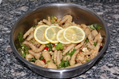 Cho chân gà luộc vào thau lớn, thêm ngò tây, tỏi, gừng và ớt vào trộn đều lên. Đổ tiếp một bát giấm nhỏ, nửa bát nước tương, một chai rượu có độ cồn cao, 10g muối, 40g đường, trộn đều. Sau đó cho những lát chanh vào trộn đều lên. Bọc màng thực phẩm, đặt trong ngăn mát tủ lạnh để qua đêm.