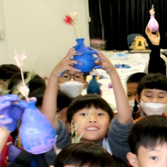 A ceramic vase decorated with colorful palm prints.