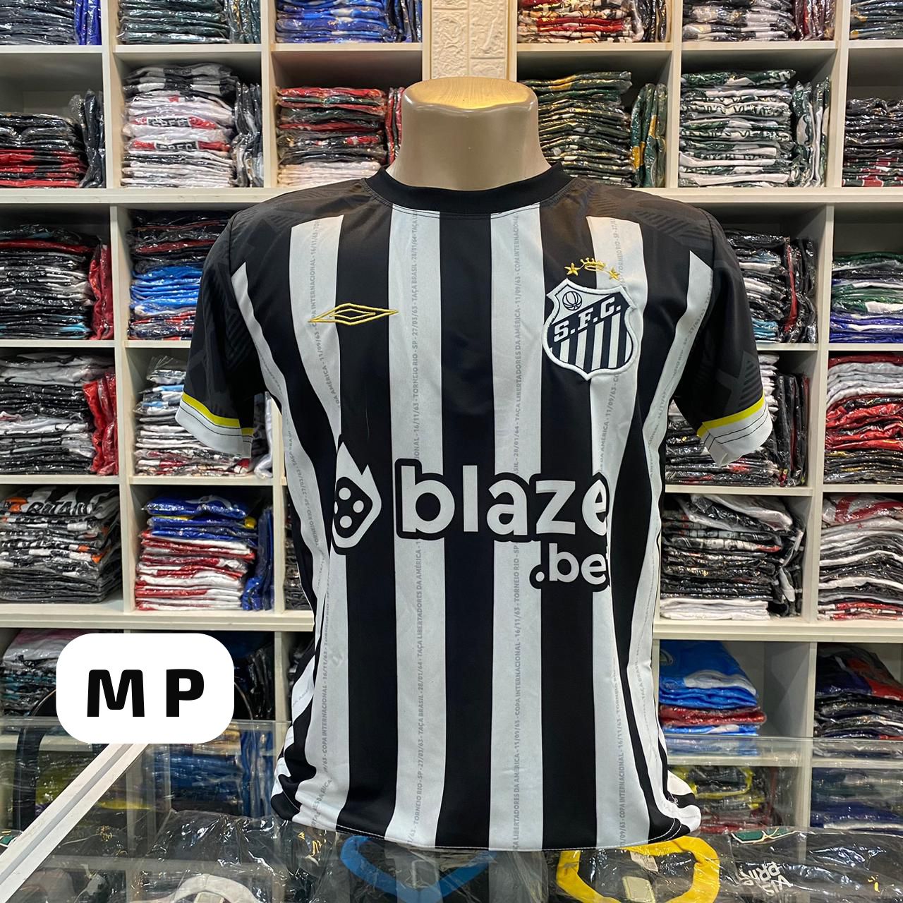 Camisa Santos S.F.C. listrada preta e branca com logo Umbro e patrocinador Blaze.bet – Atacado no Brás
