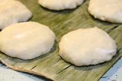 Làm bánh khoai mì: Trộn khoai mì, đậu xanh đã nghiền, 1 muỗng canh sữa đặc, 60g đường trắng, 50ml nước cốt dừa, 2 muỗng canh bột năng, 100g dừa nạo vào 1 cái tô. Vo tròn hỗn hợp bánh khoai mì rồi ấn dẹp.