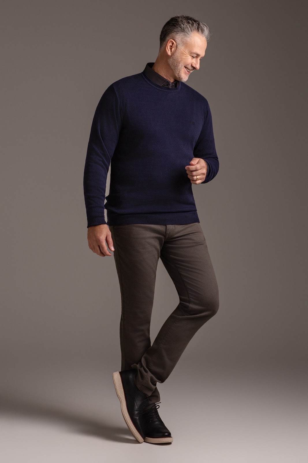 Retrato masculino de corpo inteiro com blazer cinza e poltrona no Est�dio TACCA.