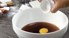 Chuẩn bị phần vỏ bánh trung thu trứng muối lava: chuẩn bị một chiếc tô sạch, cho 300gr nước đường, 50ml dầu ăn, 1 lòng đỏ trứng gà vào tô rồi đánh tan đều. Tiếp theo thêm 500gr bột mì đa dụng vào tô rồi dùng trộn đều, sau đó nhồi sơ để tạo thành một khối bột mịn. Bọc kín bột rồi để bột nghỉ 1 tiếng.