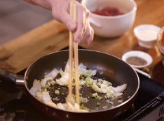Phi thơm tỏi bằm và sả bằm còn lại với 1 muỗng canh dầu ăn, cho hành tây và hành lá cắt nhỏ vào, đảo đều. Cho thịt bò vào, xốc đều đến vừa chín, tắt bếp.