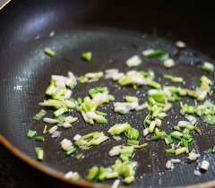 Dùng chảo khác, đun nóng 2 muỗng canh dầu ăn. Cho đầu hành vào phi thơm. Thêm mướp vào đảo đều. Thêm 2-3 muỗng canh nước lọc vào xào cùng cho mướp mau chín.