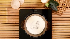 Trộn 600g nước cốt dừa, 100g nước lọc, 15g bột gạo, 15g bột bắp. 5g muối, 120g đường cho đều. Sau đó cho 1 nhúm lá dứa vào và bắt đầu nấu ấm với lửa nhỏ, khuấy liên tục cho tới khi hỗn hợp nước cốt dừa sệt lại.