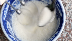 Đánh bông kem sữa tươi lên, từ từ cho 1 muỗng cà phê đường. Khi thấy nhiều đường vân xuất hiện khi đi máy, hạ tốc độ thấp xuống, đánh thêm 15 giây nữa, đến khi đạt chóp đứng. Rây 20g bột dừa vào trộn với kem tươi cho béo và thơm, cũng trộn theo kiểu fold.