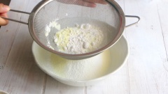 Chuẩn bị phần bột thứ 2 của vỏ bánh bao nhân thịt: rây bột mì, sữa bột, đường bột và bột nở vào 1 tô chung với nhau. Dùng phới lồng trộn thật đều các nguyên liệu.
