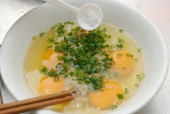 Trứng gà đập ra tô, thêm hành lá, 1 muỗng canh nước mắm, 1 muỗng cà phê hạt nêm, 1/2 muỗng cà phê tiêu, 1/2 muỗng cà phê bột ngọt vào, khuấy đều.