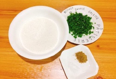 Hành lá thái nhỏ. Rây 200g bột mì, 3g muối vào tô, rót từ từ nước sôi vào tô bột, khuấy vào dùng tay nhồi cho bọt nở và thành khối đồng nhất là được. Tránh cho 1 lần nhiều nước sôi bột sẽ nhảo nhé!