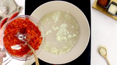Bắc chảo nóng, rót vào 2 muỗng canh dầu ăn, cho 15gr tỏi băm vào phi thơm. Sau đó cho hết số ớt vừa xay vào. Thêm 150gr đường, 2 muỗng cà phê muối rồi đảo đều tay cho đường tan hết.