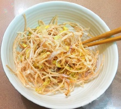 Mực sau khi xé sợi nhỏ, ướp với 1 muỗng canh rượu trắng, 1 muỗng canh dầu ăn, gừng và 1/2 muỗng canh đường để khoảng 15-20 phút cho mực thấm gia vị. Đặt nồi lên bếp, khi dầu nóng già cho chỗ tỏi bằm ở trên vào phi thơm. Tỏi vàng đều, nhanh tay vớt riêng ra đĩa. Sau đó cho mực đã ướp gia vị ở trên vào chiên vàng, vớt ra đĩa có lót giấy thấm dầu để loại bỏ bớt dầu.