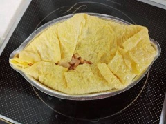 Làm nóng chảo cùng với ít bơ. Khi chảo nóng thì cho 1/2 trứng vào chiên chín, tráng trứng khắp mặt chảo nhé. Chiên trứng chín thì lót trứng vào khuôn rồi cho cơm vào giữa nén chặt. Sau đó dùng muỗng gấp viền trứng cho trứng ôm cơm rồi ép lại. Hoàn tất.