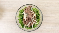 Cho 300gr rau càng cua, 100gr cà chua bi bổ đôi vào tô trộn, trút nhanh cả chảo thịt bò vào tô, thêm 20gr ớt sừng thái chỉ. Đổ nước mắm trộn gỏi vào trộn nhanh tay. Hơi nóng từ thịt sẽ làm rau dậy mùi thơm và tái vừa đủ.