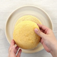 Cắt giữa bánh bông lan. Phần giữa của bánh: phủ đều lớp kem dứa lên mặt bánh. Phần bên ngoài của bánh: phủ đều lớp kem dứa lên xung quanh mặt, lớp cuối cùng rải cơm dừa khắp mặt.
