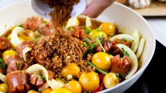 Bây giờ chúng ta mới cho 30gr hành tây, 10gr ớt sừng, 10gr hành lá, 10r cần tàu vào. Xào tất cả lên cho các nguyên liệu trộn lẫn vào nhau. Khi hành tây vừa chuyển trong thì cho thêm tỏi phi vàng đã làm sẵn, đảo nhẹ rồi nhắc chảo xuống.