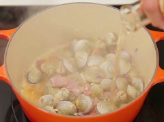 Nghêu ngâm nước, thả vào ớt cải nhỏ, ngâm khoảng 2-3 tiếng choi nhả sạch cát. Hành lá, ngò rí, thịt xông khói, hành tím, tỏi thái nhỏ. Đun nóng 1 muỗng canh dầu ăn, xào tỏi và hành tím, thịt xông khói cho thơm. Sau đó cho nghêu vào, cho rượu vang trắng và đun nhỏ lửa trong 3 phút.