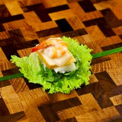Xếp lần lượt rau xà lách, húng lủi, ngò rí, bún lá, thịt, trứng, đậu hủ, tôm chồng lên trên nhau, rồi dùng cọng hành lá đã chần sơ cột cố định lại.