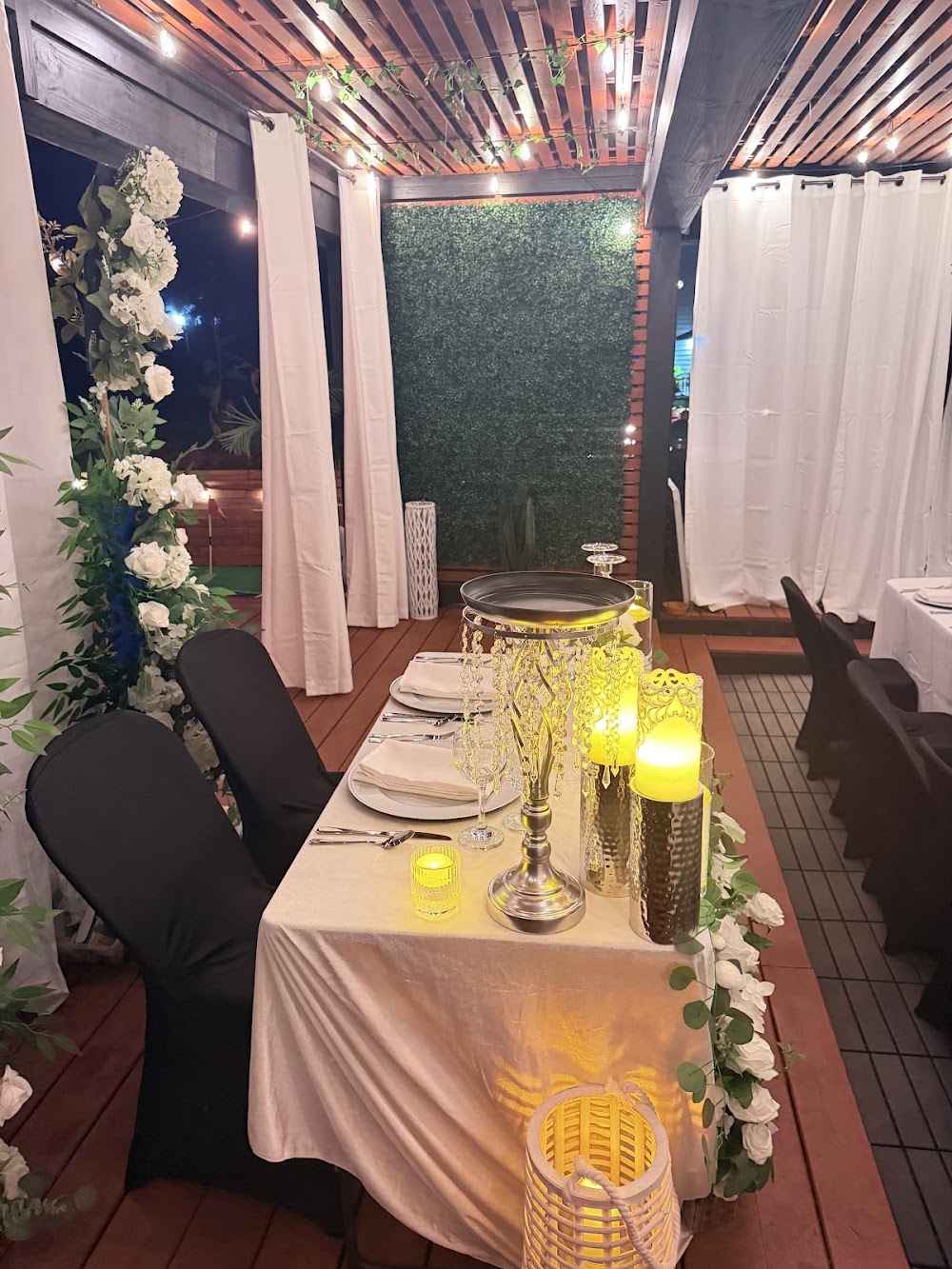 Sweetheart table with floral arch and candlelight on the outdoor patio
