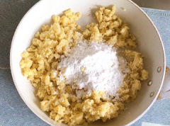 Nghiền nhuyễn khoai. Thêm 100gr bột năng cùng 1 tsp đường trắng vào, trộn đều lên. Dùng tay nhào nặn khoai với bột thành một khối dẻo mịn. (Chú ý là không nên cho thêm nước vào, vì bản thân khoai đã đủ ẩm rồi.) Bọc wrap lại cho khoai không bị khô.